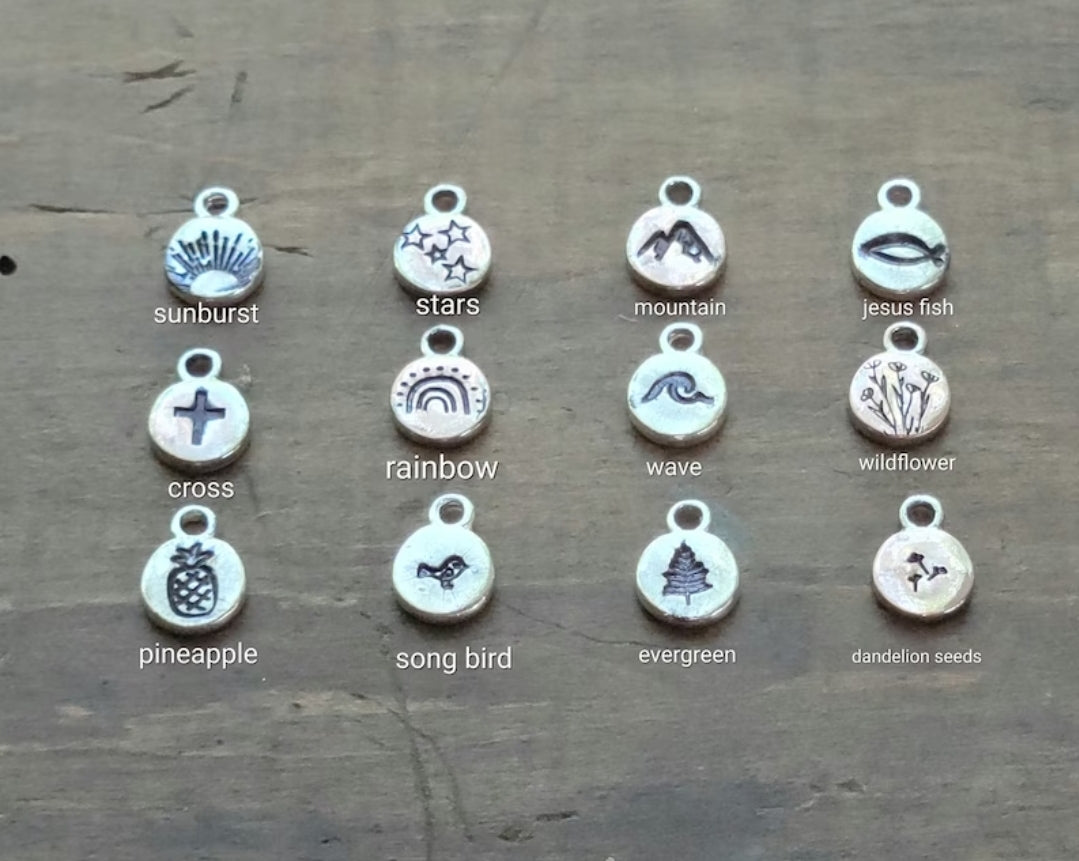 Twelve Silver Charm Options . Sunburst. Cross. Stars. Pineapple. Rainbow. Song Bird. Evergreen. Mountain. Wave. Jesus Fish. Wildflowers. Dandelion Seeds